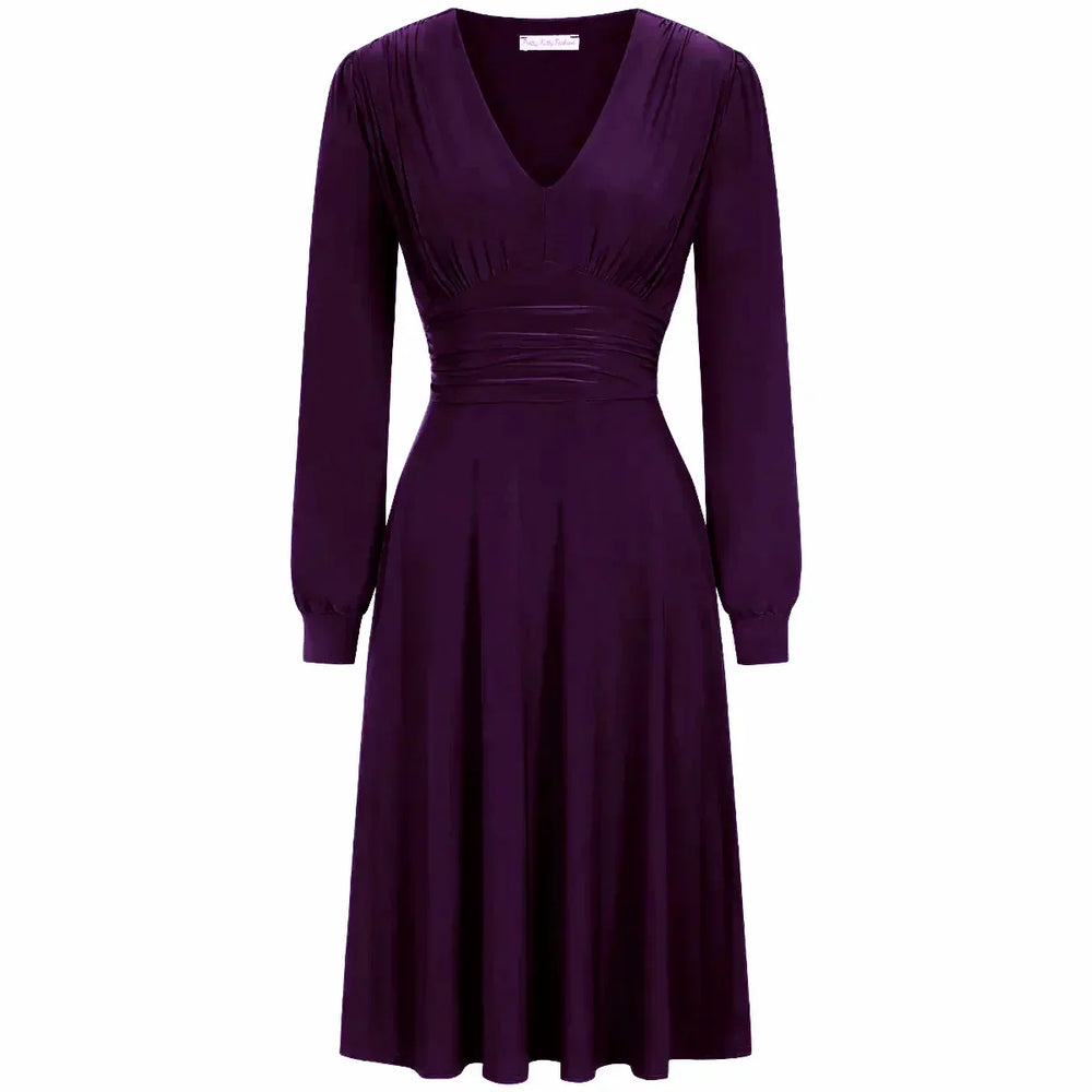 A red long sleeve ruched deep V-neck dress with a knee-length skirt.