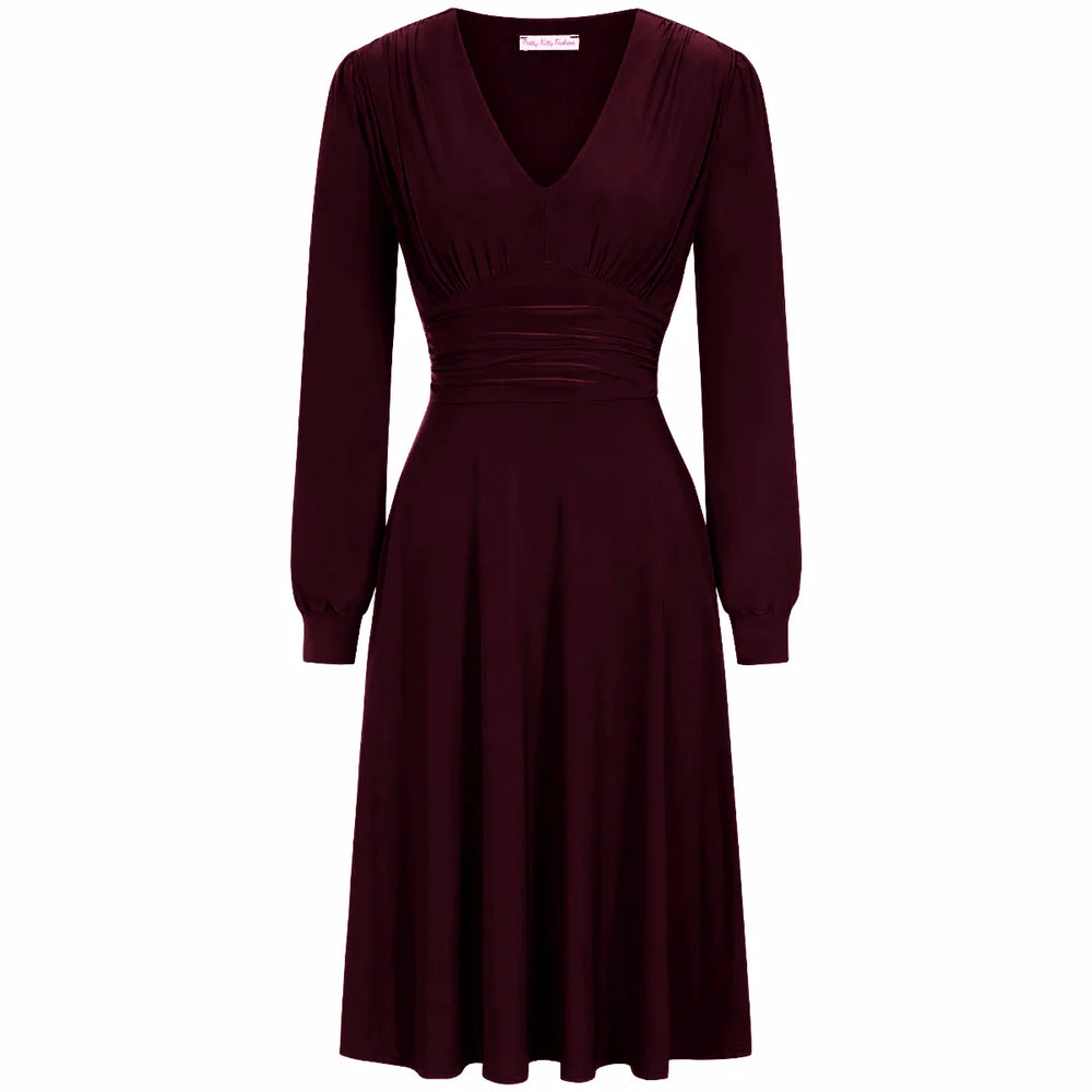 A red long sleeve ruched deep V-neck dress with a knee-length skirt.